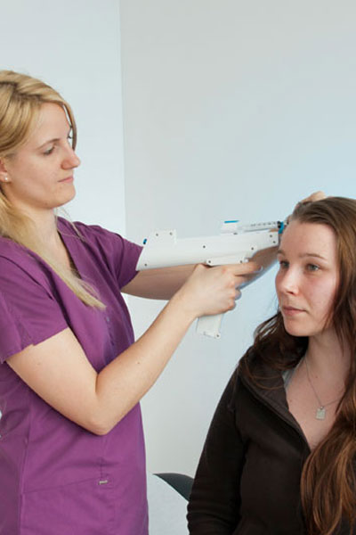 Eine Frau führt eine Hautuntersuchung bei einer Patientin durch